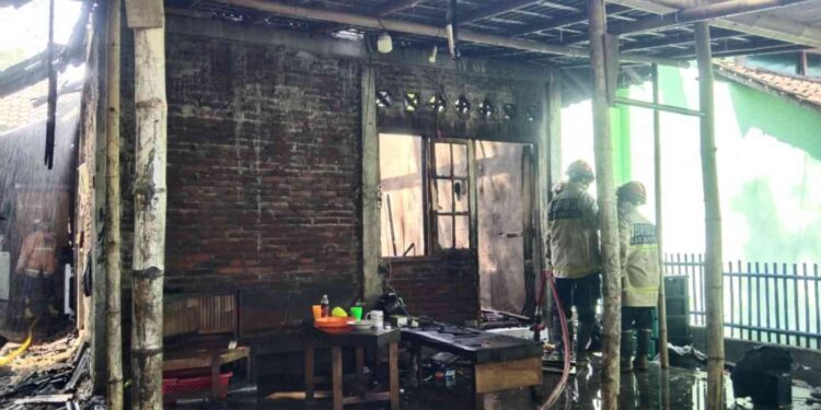 Petugas BPBD Bantul memadamkan sisa api di rumah milik Endra Yulio Pratama di Dusun Paten, Sumberagung, Jetis, Bantul