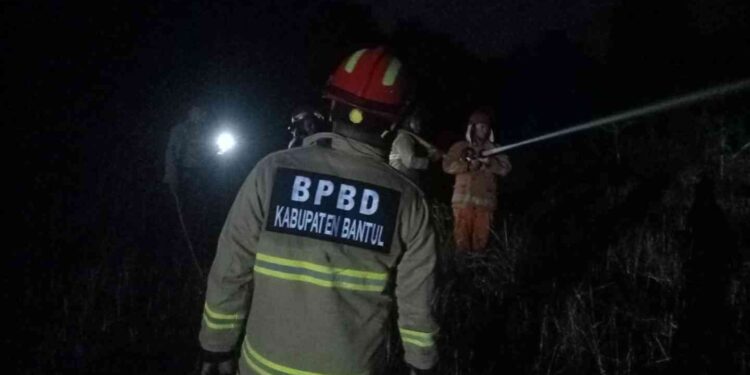 Petugas Damkar saat berjibaku memadamkan api yang membakar lahan kosong di Dusun Bandut Lor, Argorejo, Sedayu