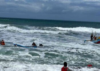 Petugas Satlinmas Rescue Istimewa dan Ditpolair Polda DIY mengevakuasi nelayan yang perahunya terbalik di Pantai Depok, Bantul