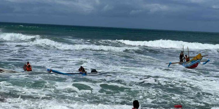 Petugas Satlinmas Rescue Istimewa dan Ditpolair Polda DIY mengevakuasi nelayan yang perahunya terbalik di Pantai Depok, Bantul