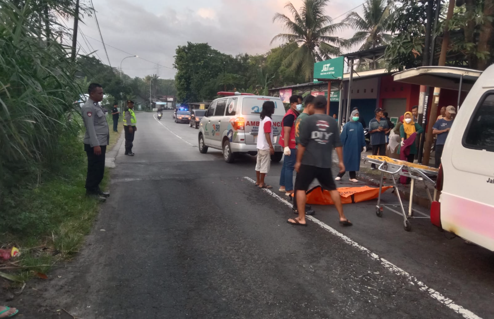 Petugas kepolisian bersama Tim Medis dan warga mengevakuasi jenazah korban kecelakaan lalu lintas di sekitar Pasar Butuh, Bumirejo, Lendah, Kulon Progo, Minggu (7/9/2025) pagi.