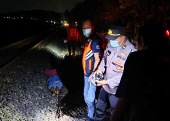 Petugas kepolisian bersama medis mengevakuasi korban kecelakaan tertemper KA Bogowonto di perlintasan Km 522+1, Sentolo, Kulon Progo
