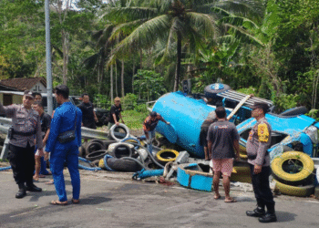Petugas kepolisian bersama warga mengevakuasi truk tangki penyedot limbah yang terguling di Simpang Tiga Balong, Sermo Lor, Hargowilis, Kokap, Kulon Progo