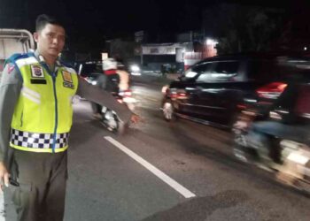 Petugas kepolisian menunjukkan lokasi kecelakaan lalu lintas di Jalan Raya Yogya-Wates, Sedayu, Bantul