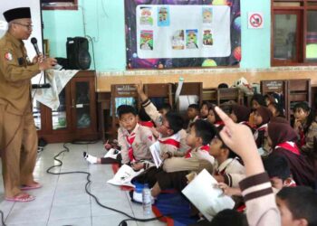 Frika Deddy Sofyan dari DLH Bojonegoro bersama Kepala SDN Kadipaten 1 Bojonegoro, Budiono memberi edukasi siswa tentang pengelolaan sampah