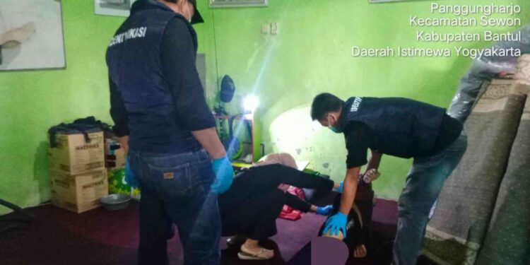 Petugas kepolisian bersama tim medis melakukan pemeriksaan karyawan rental mobil yang meninggal di Bantul