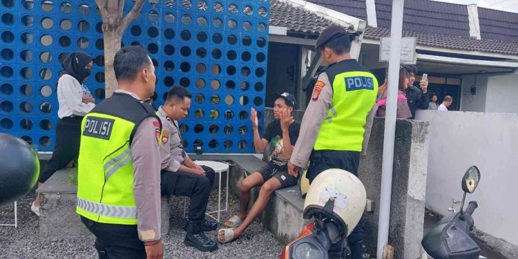 Petugas Polsek Depok Barat memeriksa keterangan seorang saksi terkait kasus penganiayaan menggunakan senjata tajam di kawasan Demangan Baru, Caturtunggal, Depok, Sleman, Senin (15/12/2025).