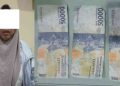 Petugas Polsek Mergangsan mengamankan seorang perempuan terduga pelaku peredaran uang palsu beserta barang bukti tiga lembar uang pecahan Rp50.000 yang diduga palsu saat pengungkapan kasus di Pasar Prawirotaman, Kota Yogyakarta, Rabu (31/12/2025).