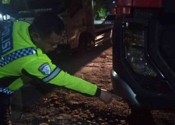 Petugas Satlantas Polresta Sleman melakukan olah tempat kejadian perkara (TKP) kecelakaan lalu lintas yang melibatkan sepeda motor dan truk wing box di Jalan Padjajaran