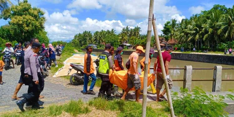 Petugas gabungan dari kepolisian, SAR, PMI, dan warga mengevakuasi jasad perempuan tanpa identitas yang ditemukan mengapung di Sungai Bedoyo, Karangsewu, Galur, Kulon Progo, Minggu (28/12/2025).