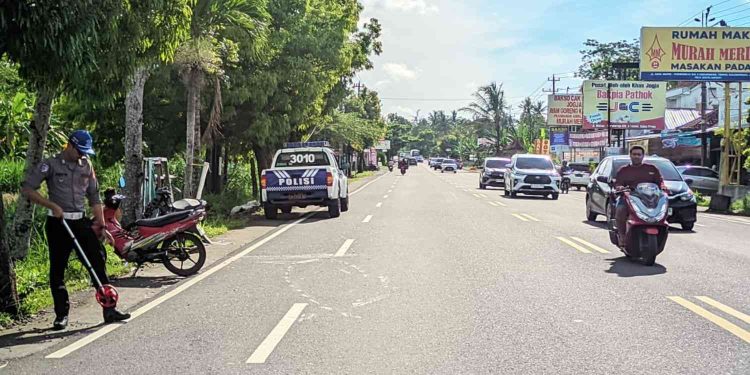 Petugas kepolisian melakukan olah tempat kejadian perkara (TKP) kecelakaan lalu lintas yang melibatkan dua sepeda motor di Jalan Wates–Yogyakarta, wilayah Temon, Kulon Progo, Minggu (28/12/2025)
