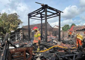 Petugas pemadam kebakaran melakukan proses pendinginan dan penyisiran sisa material bangunan pendopo joglo yang hangus terbakar di Sayangan, Jagalan, Banguntapan, Bantul, Kamis (25/12/2025).