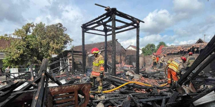 Petugas pemadam kebakaran melakukan proses pendinginan dan penyisiran sisa material bangunan pendopo joglo yang hangus terbakar di Sayangan, Jagalan, Banguntapan, Bantul, Kamis (25/12/2025).
