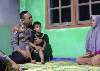 Kapolres Kulonprogo AKBP Ridho Hidayat berdialog dengan Ibu Rubiyanti sambil menggendong Reyfan, adik dari Ariendra, saat melakukan silaturahmi dan memberikan dukungan moril kepada keluarga di Kalurahan Salamrejo, Sentolo, Kulonprogo.