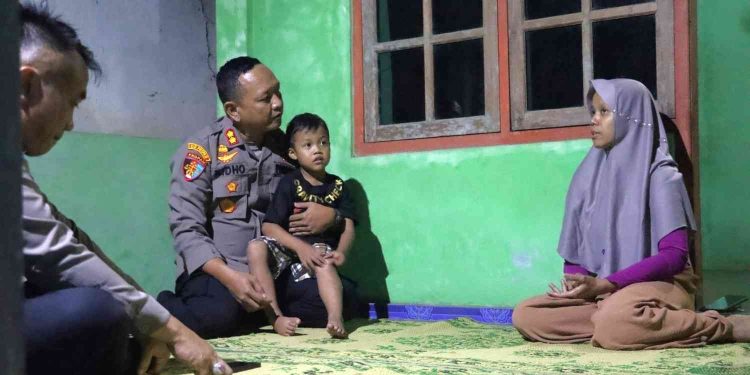 Kapolres Kulonprogo AKBP Ridho Hidayat berdialog dengan Ibu Rubiyanti sambil menggendong Reyfan, adik dari Ariendra, saat melakukan silaturahmi dan memberikan dukungan moril kepada keluarga di Kalurahan Salamrejo, Sentolo, Kulonprogo.