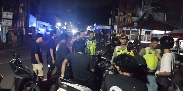Petugas kepolisian berjaga dan melakukan pengamanan di lokasi keributan antara warga Karanggayam dan rombongan pengendara sepeda motor di Jalan Sitimulyo–Segoroyoso, Piyungan, Bantul, Kamis (1/1/2026) dini hari.