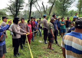 Petugas kepolisian bersama tim gabungan memasang garis polisi di lokasi penemuan mayat di kawasan Gumuk Pasir Parangtritis, Kretek, Bantul, Rabu (28/1/2026).