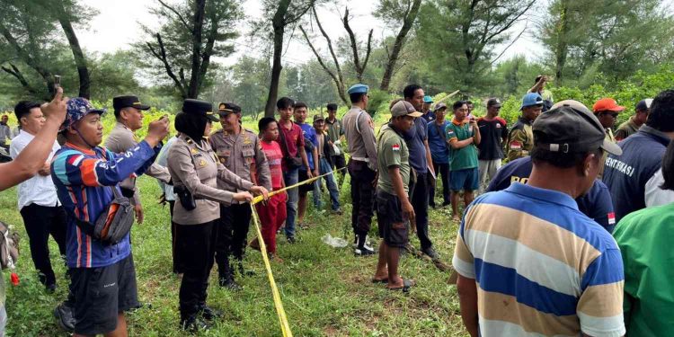 Petugas kepolisian bersama tim gabungan memasang garis polisi di lokasi penemuan mayat di kawasan Gumuk Pasir Parangtritis, Kretek, Bantul, Rabu (28/1/2026).