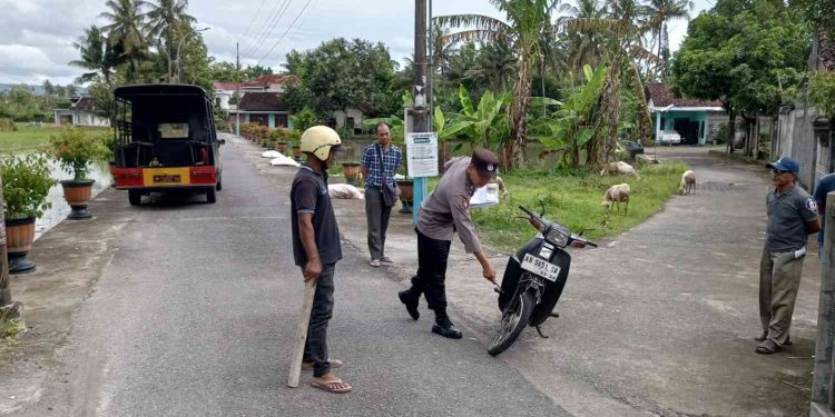 Petugas kepolisian bersama warga melakukan olah tempat kejadian perkara (TKP) kecelakaan lalu lintas di Jalan Kampung Daleman, Dusun Bajang Glondong, Gilangharjo, Pandak, Bantul, Kamis (15/1/2026). Sepeda motor Honda Astrea tampak mengalami kerusakan usai bertabrakan dengan mobil Honda Jazz, mengakibatkan satu pengendara perempuan mengalami patah tulang dan dirawat di rumah sakit.