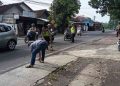 Petugas kepolisian bersama warga membersihkan sisa material di lokasi kecelakaan lalu lintas di Jalan Imogiri Timur, tepatnya di depan SMKN 1 Pleret, Bantul