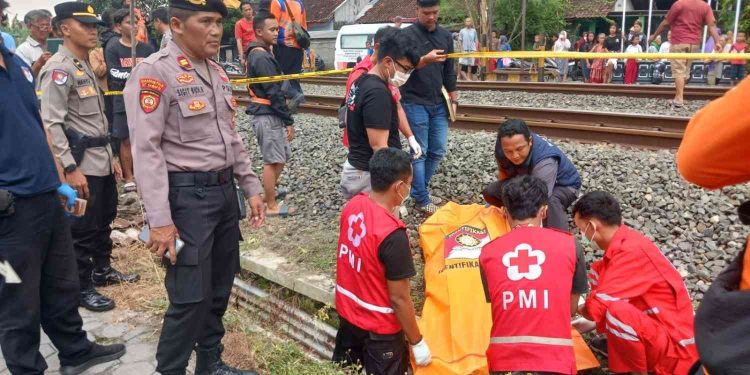 Petugas kepolisian dan medis melakukan evakuasi korban tertemper kereta api di Bantul