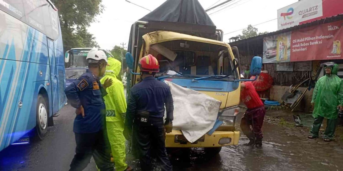Petugas kepolisian dan relawan mengevakuasi truk engkel yang ringsek akibat kecelakaan beruntun di Jalan Parangtritis, Tembi, Sewon, Bantul, Minggu (11/1/2026). Insiden ini melibatkan tiga kendaraan dan menyebabkan satu pengemudi mengalami patah kaki serta beberapa penumpang luka ringan.