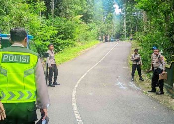 Petugas kepolisian melakukan olah tempat kejadian perkara (TKP) di ruas Jalan Tegalsari–Klepu, Turunan Sokomoyo, Girimulyo, Kulon Progo, lokasi kecelakaan lalu lintas tunggal yang menewaskan dua pemuda pada Senin (26/1/2026).