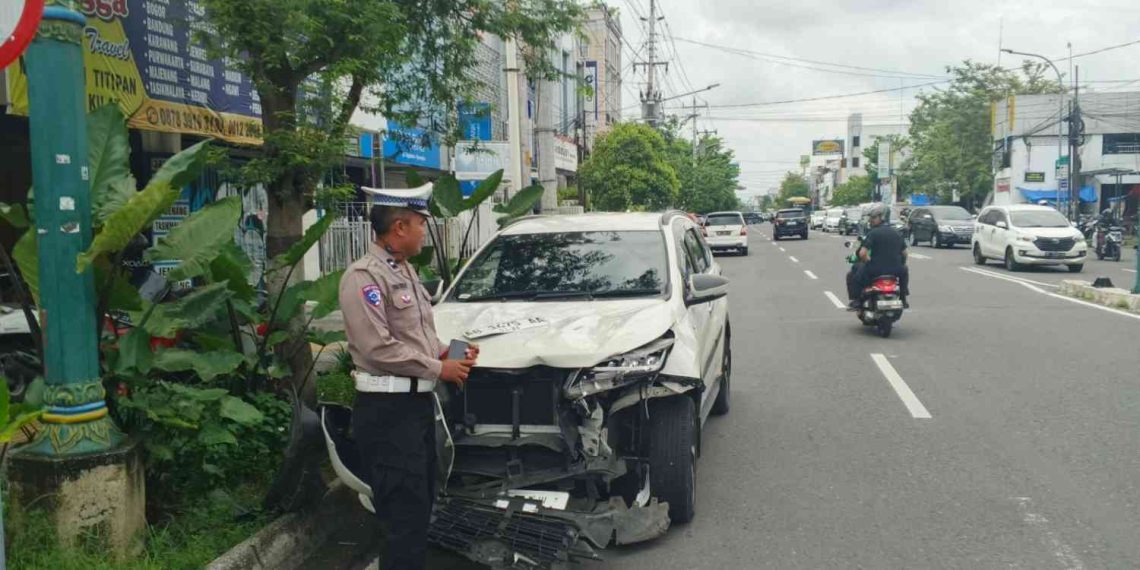 Petugas kepolisian melakukan pengamanan dan pendataan di lokasi kecelakaan lalu lintas yang melibatkan mobil Toyota Rush di Jalan Pangeran Diponegoro, Yogyakarta, Minggu (18/1/2026).