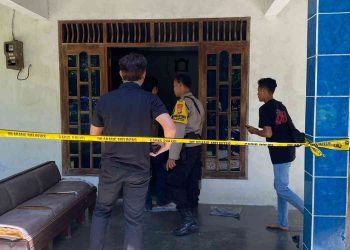 Petugas kepolisian memasang garis polisi saat melakukan olah tempat kejadian perkara di rumah korban dugaan pencurian uang dan perhiasan di wilayah Hargorejo, Kokap, Kulon Progo, Selasa (6/1/2026).