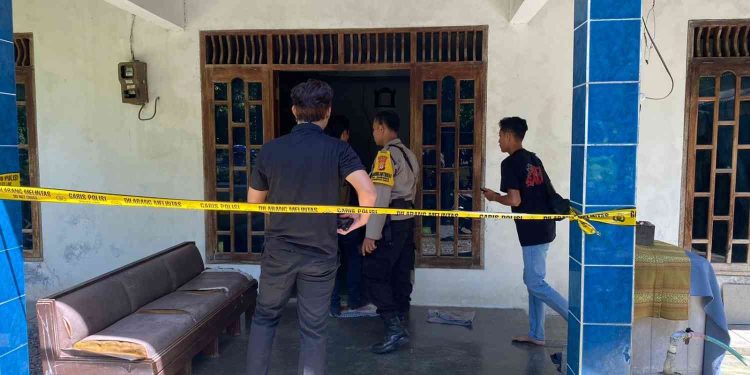 Petugas kepolisian memasang garis polisi saat melakukan olah tempat kejadian perkara di rumah korban dugaan pencurian uang dan perhiasan di wilayah Hargorejo, Kokap, Kulon Progo, Selasa (6/1/2026).