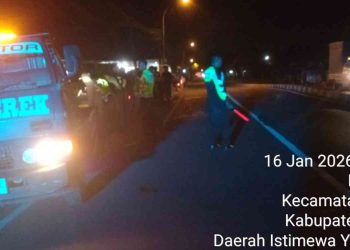 Petugas kepolisian mengamankan arus lalu lintas dan mendampingi proses evakuasi kendaraan pascakecelakaan di kawasan Margorejo, Kapanewon Tempel, Kabupaten Sleman, Jumat dini hari (16/1/2026).