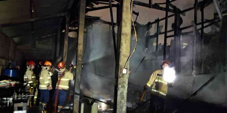 Petugas pemadam kebakaran melakukan proses pendinginan dan pemeriksaan sisa titik api di lokasi kebakaran Pabrik Keripik Tempe Kremes Pak Maryono, Bumenwetan, Banguntapan, Bantul, Sabtu (17/1/2026) dini hari. Api berhasil dipadamkan sekitar pukul 02.30 WIB dengan bantuan tiga pos damkar, dan tidak ada korban jiwa dalam peristiwa tersebut.