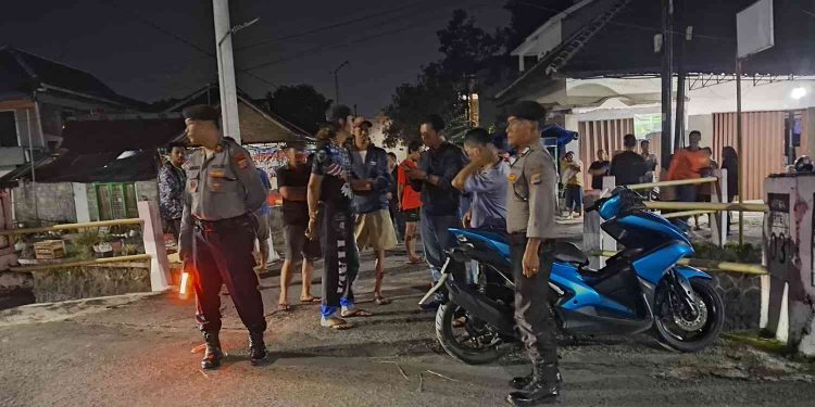 Petugas Polsek Mlati Polresta Sleman mengamankan lokasi kejadian di kawasan Jl. Selokan Mataram, Sinduadi, Mlati, usai laporan warga terkait ditemukannya seorang anak dalam kondisi tidak bernyawa pada Senin (19/1/2026) dini hari. Warga tampak berkerumun menyaksikan proses penanganan awal oleh aparat kepolisian.