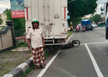 Kondisi lokasi kecelakaan lalu lintas di Simpang Empat Ngeplang, Sentolo, Kulon Progo, Sabtu (7/2/2026). Sepeda motor Honda Astrea tampak terjepit di belakang truk boks Hino setelah ditabrak akibat rem blong saat berhenti di lampu lalu lintas. Pengendara motor mengalami luka ringan dan menjalani perawatan jalan.