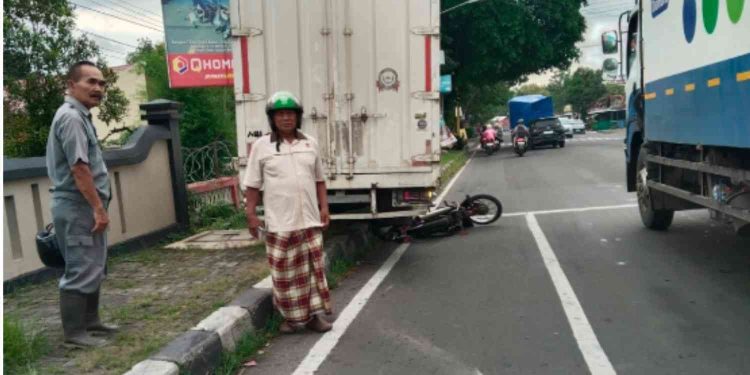 Kondisi lokasi kecelakaan lalu lintas di Simpang Empat Ngeplang, Sentolo, Kulon Progo, Sabtu (7/2/2026). Sepeda motor Honda Astrea tampak terjepit di belakang truk boks Hino setelah ditabrak akibat rem blong saat berhenti di lampu lalu lintas. Pengendara motor mengalami luka ringan dan menjalani perawatan jalan.