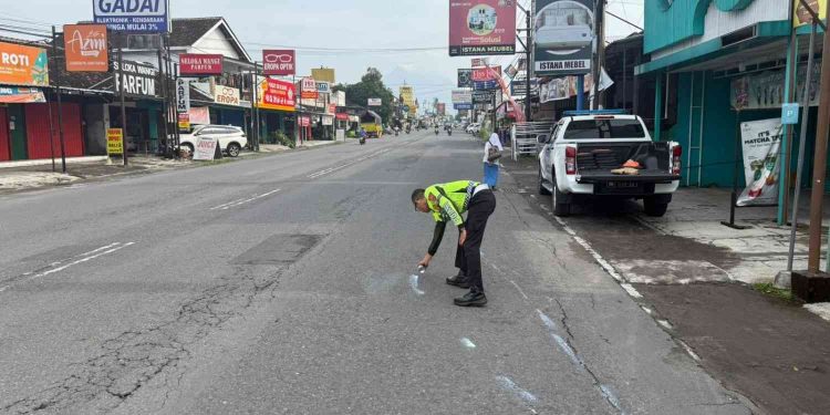 Petugas Satlantas Polresta Sleman melakukan olah tempat kejadian perkara dengan menandai titik benturan di Jalan Tajem, Maguwoharjo, Depok, Sleman, Sabtu (21/2/2026), usai kecelakaan tiga sepeda motor yang mengakibatkan satu pengendara meninggal dunia.