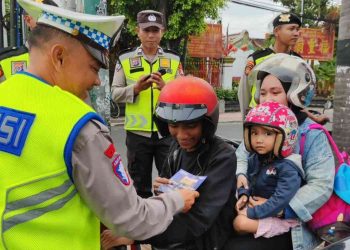 Petugas Satlantas Polresta Yogyakarta memberikan imbauan dan brosur keselamatan berlalu lintas kepada pengendara sepeda motor di wilayah Kota Yogyakarta dalam rangka Operasi Keselamatan Progo 2026.