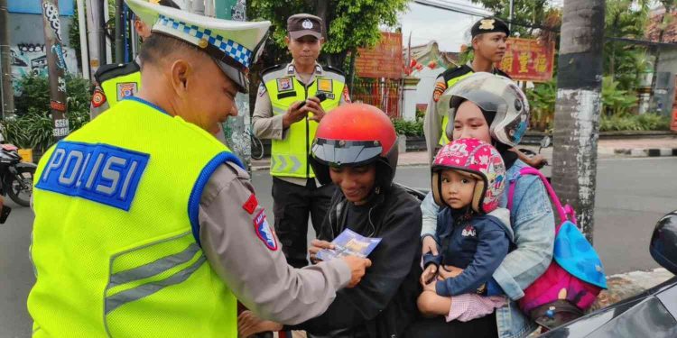 Petugas Satlantas Polresta Yogyakarta memberikan imbauan dan brosur keselamatan berlalu lintas kepada pengendara sepeda motor di wilayah Kota Yogyakarta dalam rangka Operasi Keselamatan Progo 2026.