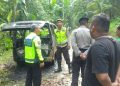 Petugas kepolisian bersama warga meninjau kondisi mobil Espas yang terbakar akibat dugaan korsleting listrik di jalan perkampungan Margosari, Pengasih, Kulon Progo, Kamis (19/2/2026). Tidak ada korban jiwa dalam peristiwa tersebut setelah api berhasil dipadamkan petugas pemadam kebakaran.