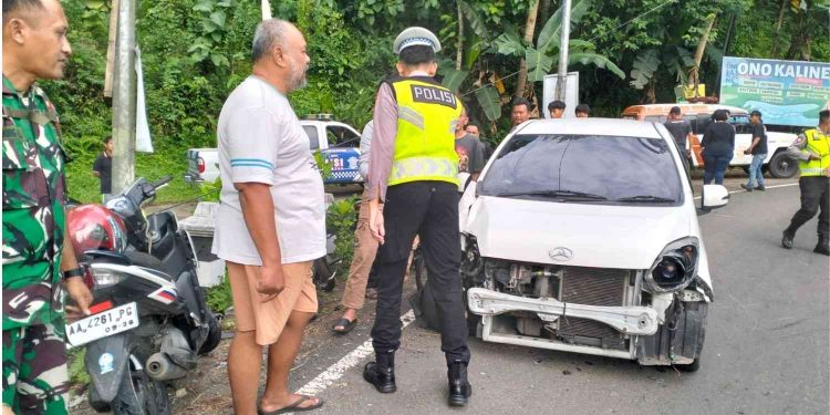 Petugas kepolisian melakukan olah tempat kejadian perkara (TKP) kecelakaan lalu lintas yang melibatkan sebuah minibus dan sepeda motor di Jalan Kawasan Industri, Kalibawang, Kulon Progo, Kamis (5/2/2026).