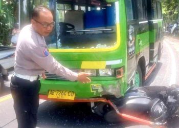 Petugas kepolisian menunjukkan kondisi bagian depan mikrobus Mitsubishi Colt yang mengalami kerusakan usai terlibat kecelakaan dengan sepeda motor Honda Beat di Jalan Jogja–Wonosari Km 25, Padukuhan Kerjan, Patuk, Gunungkidul, Kamis (12/2/2026). Dalam insiden tersebut, pengendara sepeda motor mengalami luka serius dan harus menjalani perawatan di rumah sakit.