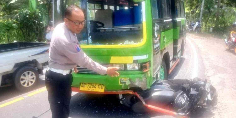 Petugas kepolisian menunjukkan kondisi bagian depan mikrobus Mitsubishi Colt yang mengalami kerusakan usai terlibat kecelakaan dengan sepeda motor Honda Beat di Jalan Jogja–Wonosari Km 25, Padukuhan Kerjan, Patuk, Gunungkidul, Kamis (12/2/2026). Dalam insiden tersebut, pengendara sepeda motor mengalami luka serius dan harus menjalani perawatan di rumah sakit.