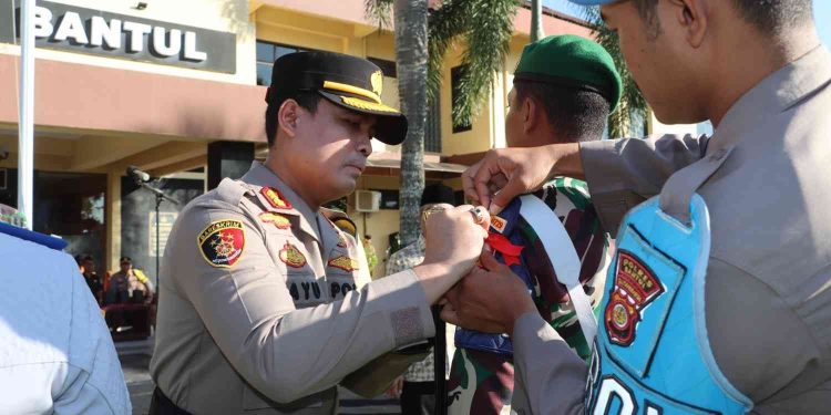 Kapolres Bantul menyematkan pita tanda dimulainya Operasi Ketupat Progo 2026 kepada perwakilan personel saat Apel Gelar Pasukan di halaman Mapolres Bantul, Kamis (12/3/2026). Apel tersebut digelar untuk memastikan kesiapan personel gabungan dalam mengamankan arus mudik dan perayaan Idul Fitri 1447 Hijriah di wilayah Kabupaten Bantul.