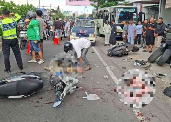 Petugas kepolisian bersama warga berada di lokasi kecelakaan lalu lintas yang melibatkan sepeda motor Honda Beat dan Honda Scoopy di Jalan Wonosari, tepatnya di depan Jakarta Ban, Banguntapan