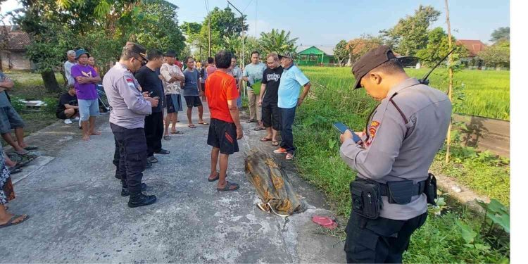 Petugas kepolisian bersama warga melakukan penanganan di lokasi penemuan jenazah seorang perempuan di aliran sungai pengairan sawah, Dusun Gesikan, Panggungharjo, Sewon, Bantul, Senin (30/3/2026) pagi. Korban ditemukan dalam kondisi meninggal dunia dan diduga terjatuh setelah mengalami benturan di sekitar talut sungai.