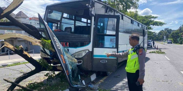Petugas kepolisian melakukan pengecekan di lokasi kecelakaan tunggal sebuah bus Hino yang menabrak pohon dan tiang lampu penerangan jalan di Jalan Ringroad Selatan, timur simpang empat Dongkelan, Sewon, Bantul, Sabtu (7/3/2026). Insiden diduga terjadi saat pengemudi bus menghindari sepeda motor yang tiba-tiba berpindah jalur, menyebabkan kerusakan pada bagian depan kendaraan dengan kerugian materi sekitar Rp5 juta.
