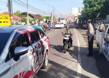 Petugas kepolisian mengatur arus lalu lintas di Jalan Jogja–Wonosari, tepatnya di kawasan Piyungan, Bantul, Kamis (23/4/2026), pascakecelakaan yang melibatkan sebuah bus dan tiga sepeda motor