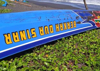 Perahu nelayan yang terbalik usai dihantam ombak besar di kawasan Pantai Baru, Bantul, Rabu (13/5/2026). Insiden saat perahu hendak mendarat dari melaut tersebut mengakibatkan tiga awak terjatuh ke laut, dua orang selamat dan satu korban masih dalam pencarian tim SAR gabungan.
