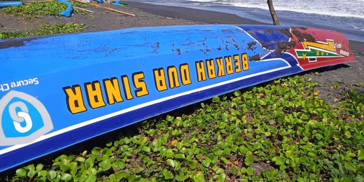 Perahu nelayan yang terbalik usai dihantam ombak besar di kawasan Pantai Baru, Bantul, Rabu (13/5/2026). Insiden saat perahu hendak mendarat dari melaut tersebut mengakibatkan tiga awak terjatuh ke laut, dua orang selamat dan satu korban masih dalam pencarian tim SAR gabungan.