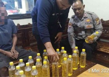 Petugas Polsek Pleret mengamankan seorang terduga pengedar miras oplosan beserta barang bukti puluhan botol minuman beralkohol jenis oplosan yang disita dalam operasi di wilayah Sewon, Bantul, Jumat (1/5/2026).